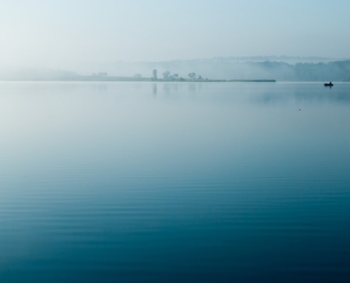 Calm reflective water surface, representing the settling of physical anxiety symptoms in the body