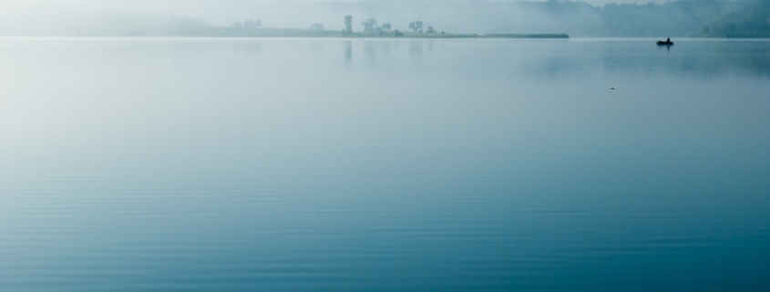 Calm reflective water surface, representing the settling of physical anxiety symptoms in the body