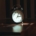 A classic alarm clock on a bedside table in soft light, representing the steady sleep and daily routine that support bipolar disorder stabilization