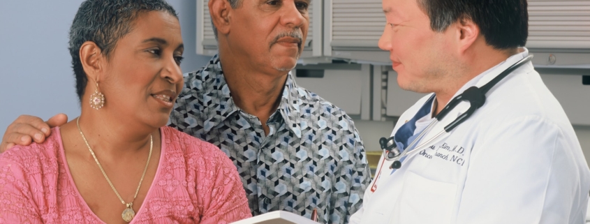 Clinician reviewing an aftercare plan on a tablet with a patient and family member during discharge planning