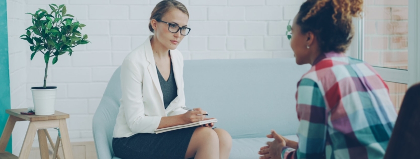 Two women talking during a therapy session for panic disorder management