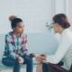 Therapist meeting with a young woman on a couch during a trauma-informed care session