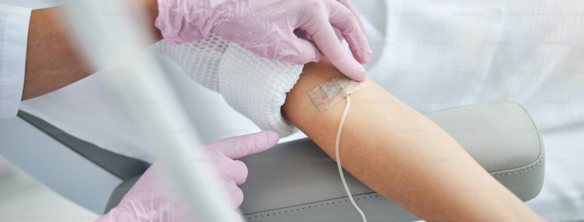 Nurse securing an IV catheter in a patient during a monitored ketamine infusion in a residential mental health setting