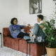 Two people sitting on a couch in a bright living room having a calm, unhurried conversation.