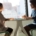 Two people in a warm supportive conversation across a table by a window