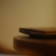 A closed laptop resting on a wooden table in soft warm light, representing stepping away from work for mental health treatment